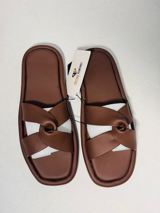Pair of brown sandals with a visible prestige tag on a light gray background