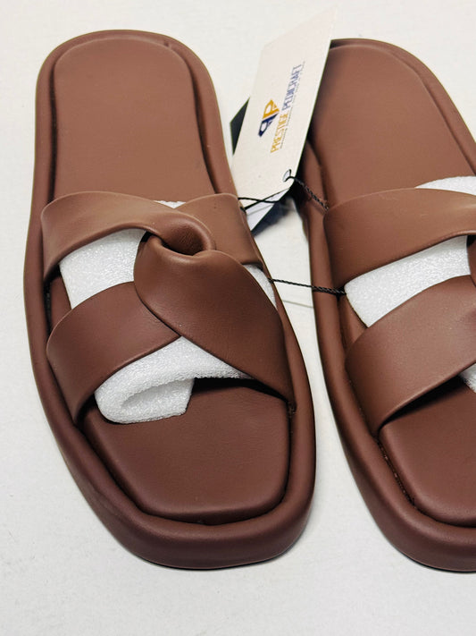 Pair of brown sandals with a white sole on a light gray background